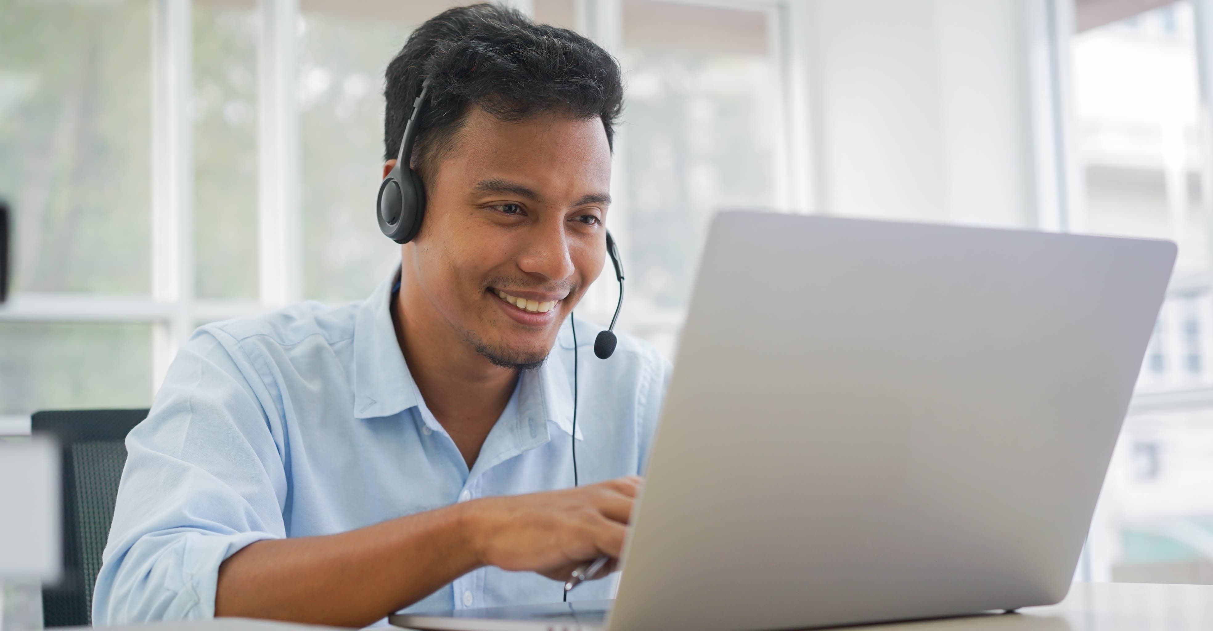 Smiling young man working on a laptop